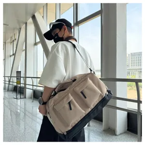 Close-up detail of a large capacity canvas duffel bag in beige with black trim, gym travel use.