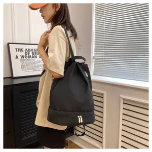 Black waterproof dry wet separation gym backpack for women and men, minimalist portable school bag.