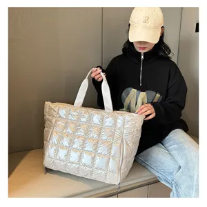 Detail view of the silver quilted puffer tote bag, showing soft texture, sturdy straps, and large capacity.