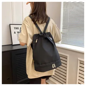 Minimalist waterproof black backpack for women and men, spacious travel and fitness bag.