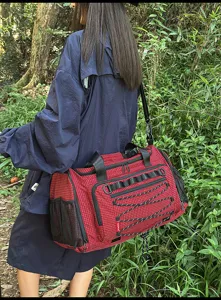 Detalle de la bolsa de viaje con tela de cuadrícula roja duradera y correas tácticas.