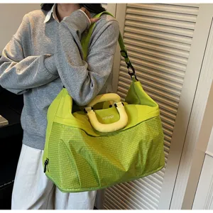 Gran bolsa de viaje en verde brillante con asas resistentes y correa de hombro ajustable.