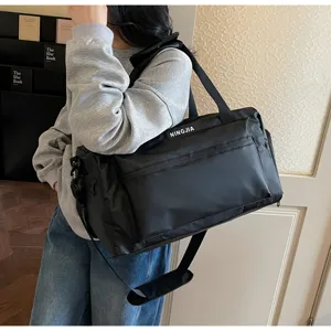 Detalle de la bolsa de viaje negra grande con tela resistente y cierres de cremallera.