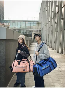 Scena all'aperto che mostra una grande borsa da viaggio con tracolla e tasche multiple.
