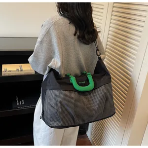 Primer plano de la bolsa de viaje grande que muestra la tela de cuadros y el asa.