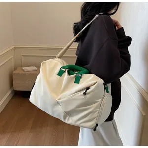 Detail shot of large white fitness gym travel bag with green handles for sports and daily use.