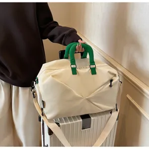 Large capacity travel duffel bag, waterproof fitness sports bag with green handles for trip.