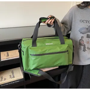 Detalle de bolsa de viaje verde, tela resistente, asas robustas y compartimento espacioso.