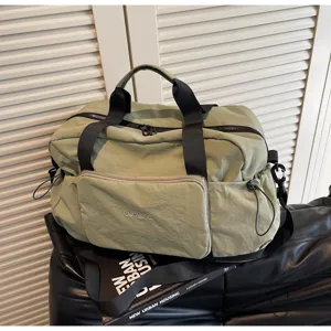 Detailaufnahme der hellgrünen Reisetasche, strapazierfähiges Nylon, schwarze Griffe, Fronttasche.