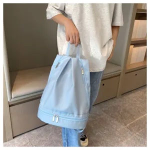 Detail view of light blue waterproof gym backpack, showing bottom dry wet compartment design.
