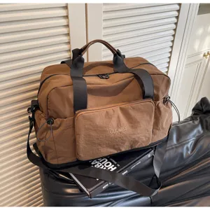 Detailansicht der braunen Reisetasche mit großer Kapazität, robustem Stoff und stabilen Griffen.