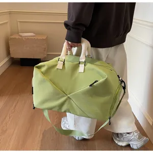 Large capacity green travel duffel bag with white handles and adjustable strap detail view