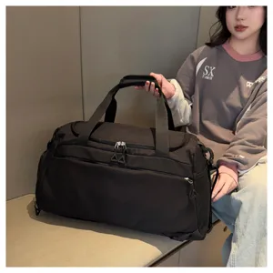 Vue détaillée du grand sac de voyage sport noir avec doubles poignées et poche filet.