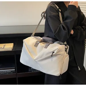 Detailed view of the large capacity travel duffel bag with shoulder strap in neutral beige.