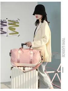 Detail shot of pink travel duffel bag on suitcase in stylish room setting with model.