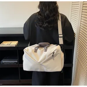 Scene detail showing the large capacity travel duffel bag worn cross-body in a modern interior.