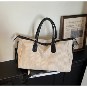 Grande borsa da viaggio con motivo spigato e manici in pelle nera per brevi soggiorni.