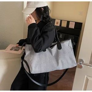 Grande borsa da viaggio in tessuto spigato bianco e nero con tracolla regolabile.