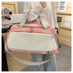 Vue détaillée du grand sac de voyage rose avec doubles poignées et fermeture éclair robuste.