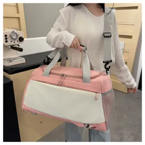 Vue détaillée du sac de voyage léger rose et blanc avec sa bandoulière réglable.