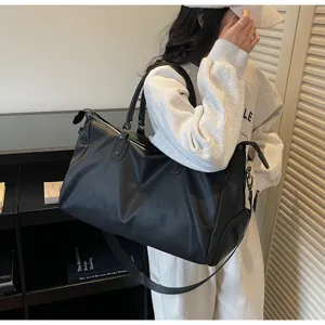 Grande borsa da viaggio nera con tracolla, ideale per sport e brevi viaggi quotidiani.