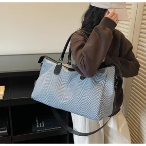 Grande borsa da viaggio con elegante motivo a spina di pesce, ideale per i fine settimana.
