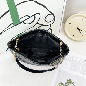 Schwarze gesteppte Umhängetasche mit goldener Kette, stilvolle Damen Achseltasche chic.