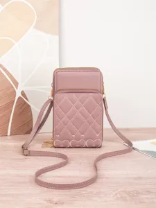 Nahaufnahme der rosafarbenen gesteppten Handytasche mit filigraner Herzstickerei im Detail.