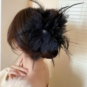 Detailed view of elegant black feather flower hair claw clip for charming hairstyles.