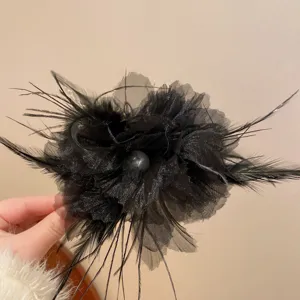 Black feather mesh hair claw clip detail shot highlighting texture and pearl accent.