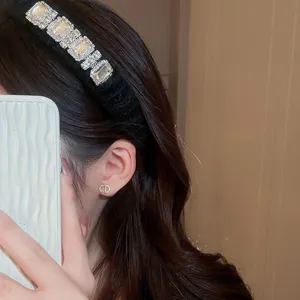 Gedetailleerd overzicht van de vintage fluwelen strass haarband en elegante oorbellen.