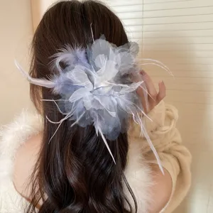 Detailed view of the elegant mesh and feather hair claw clip with pearl, perfect for styling.