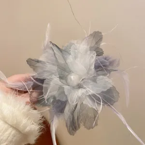 Close-up detail of the elegant feather mesh hair claw clip with pearl center for stylish updo.