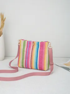 Nahaufnahme der bunten Regenbogen gewebten Umhängetasche mit rosa Riemen und goldener Hardware.