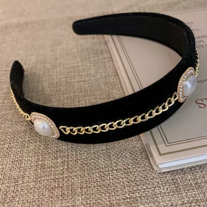Elegante zwarte fluwelen haarband met parels en gouden kettingen, vintage haaraccessoire.