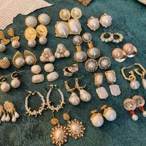 Detailed flat lay of vintage court style pearl earrings and chic retro gold ear studs.