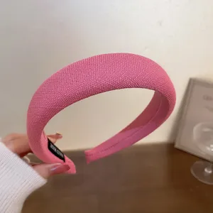 Detailansicht des stilvollen rosa gestrickten Haarreifs, weicher Stoff und modernes Design.
