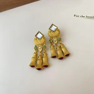Antike goldfarbene Quastenohrenringe mit Zirkonia Perlen und roten Tropfen Edelsteinen.