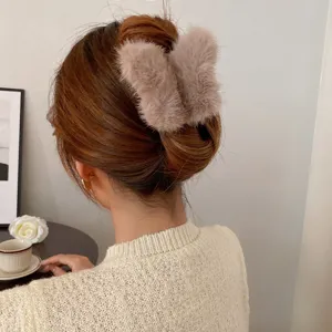 Nahaufnahme einer flauschigen Plüsch Haarklammer im Haar, gemütliches Herbst und Winter Accessoire.