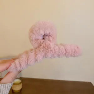 Nahaufnahme des flauschigen rosa Plüsch-Haarklammers, weiche Textur für süßen Herbststil.