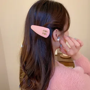 Rosa Tropfen Haarspange mit goldenen Logo Buchstaben, süßes Damen Haaraccessoire.