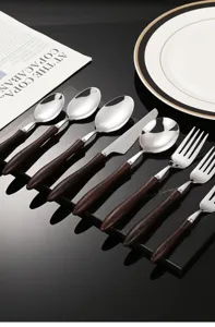 Detailed view of stainless steel tableware set with wooden handle for steak and dessert.