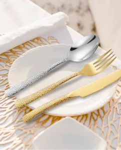 Hammered stainless steel cutlery set, elegant silver spoon and gold fork knife for dining.