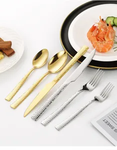 Nahaufnahme der Details des luxuriösen Edelstahl-Bestecks mit Hammerschlag, gold und silber.