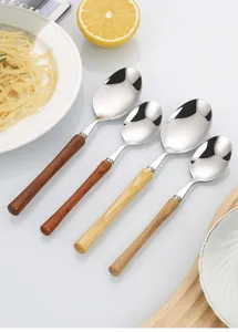 Stainless steel dinner spoon with wooden handle, elegant tableware detail view for kitchen and dining.