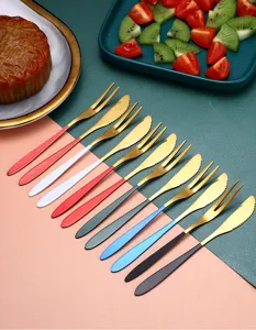 Detailed view of colorful stainless steel fruit forks and butter knives set for dessert.