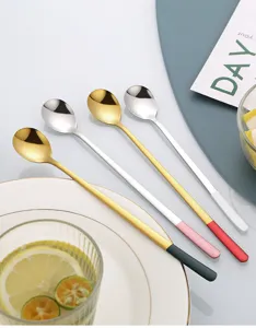 Detailed shot of long-handled stainless steel stirring spoons with colorful tips for drinks.