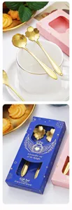 Detailed shot of gold stainless steel sakura and rose spoons in gift box packaging.