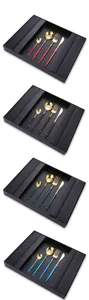Detailed view of luxury stainless steel flatware set with gold-plated heads and colorful handles.