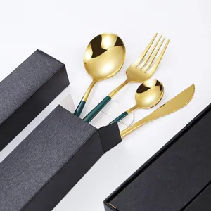 Luxury stainless steel cutlery set with gold finish and dark green handles in gift box.